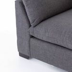 Close detail of left arm and side seam showing fabric texture and square wooden legs