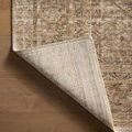 Corner of Heritage Clay / Natural rug flipped over to reveal woven backing on light wood flooring