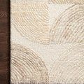 Close-up of Milo Pebble Multi Rug corner on wood floor highlighting wool texture and tonal arcs.
