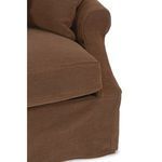 Close-up of sofa arm and seat cushion showing textured linen slipcover and stitching details