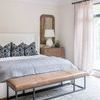 Bedroom setting with the rug under bed, showcasing scale and pattern in a neutral room.