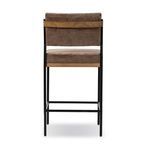 Rear view showing oak top rail behind brown fabric backrest and black iron frame