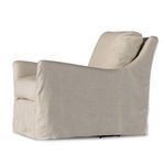 Side view of natural linen swivel chair showing sloping arm and loose back cushion profile