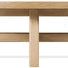 Side view of round cocktail table highlighting structural X-stretcher and wood grain detail