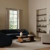 Vernon chair styled in beige room beside blue curved sofa and wooden coffee table