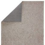 Rug pad with corner folded to reveal solid gray textured waffle-backing non-slip underside