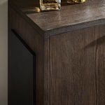 Close-up of dark iron pull handle with bottles and glasses styled on sideboard top
