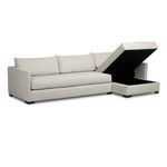 Chaise cushion lifted to reveal black storage compartment underneath