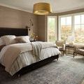 Jules Emerald / Antique Ivory Rug styled under bed in bright bedroom with neutral walls and gold pendant light.