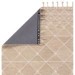 Partial rug flipped to show smooth grey non-slip backing with branded Nikki Chu strip