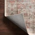 Back side corner view revealing woven backing and finished edge of rug on wooden floor