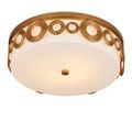 Side view showing circular brass pattern wrapping around opaque white glass shade