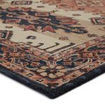 Close-up of rug corner showing looped pile texture and detailed multicolor border