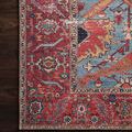 Detailed macro shot of Loren rug’s red border and floral motifs on dark wood flooring