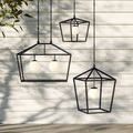 Outdoor setting with multiple metal frame lanterns hanging against white siding