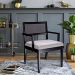 Chair styled in a modern living room setting with gray panel wall, gold bar cart, and plants