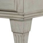 Detailed close-up of tapered leg with carved vertical grooves and distressed white finish