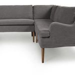 Close-up of seating area corner highlighting fabric texture and tapered wood legs