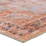 Close-up of rug corner showing woven texture and detailed rust, navy, and blue patterns