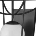Close-up of curved metal arch features above and below central white glass globe