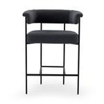 Black bar stool elevated on black metal legs shown from front against white background