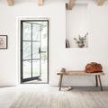 Bellamy Grey Rug laid in a bright entryway with natural wood bench and open glass door