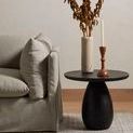 Living room scene with black Merla Wood End Table holding decor beside sectional sofa