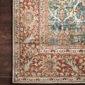 Close view of rug border pattern with rust floral designs on dark hardwood flooring
