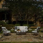 Outdoor patio setting with Monaco Aluminum Spring Lounge Chairs and sofa arranged around a low table