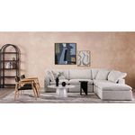 Clay Dream sectional styled in a modern living room with abstract wall art, wooden chairs, and layered area rugs