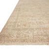 Angled close-up displaying textured weave and fringed edge of ivory rug on a white background