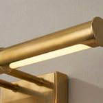 Close-up of lit aged brass light bar showing smooth metal texture and integrated lighting strip