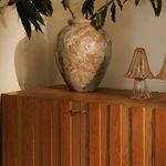 Oak sideboard styled with ceramic vase and glass lamps, showing warm natural tones in ambient lighting