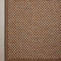 Top-down corner of the rug on a smooth floor surface, highlighting weave detail and border