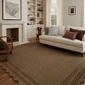 Scottie Mocha / Clay rug styled in a living room with white sofa and built-in shelving