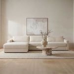 Farrow Sectional styled in a neutral living room with a textured rug, marble coffee table, and wall art