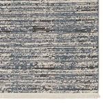 Detailed view of the distressed horizontal stripes and fringe on the blue and gray modern area rug