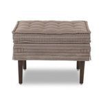 Back view of ottoman showing symmetrical tufting and fabric skirt with hemmed edges