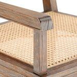 Close-up of armrest detail showing weathered wood grain and cane weaving on seat
