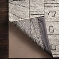 2x8 foot grip rug pad with waffle texture underside showing cushion and anti-slip surface beneath beige patterned area rug