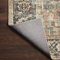 Margot rug corner lifted to expose light gray non-slip backing on hardwood floor
