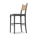 Side angle showing full profile with balanced curved legs and paper cord back on stool