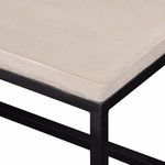 Detailed view of textured matte stone bench surface and contrasting black metal frame edges