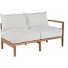Snowy white cushions arranged on teak sofa frame with visible wood grain