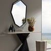 Tiago Sculpture placed on a console table beneath a geometric mirror in a minimalist room with ocean view