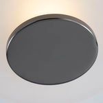 Close-up of the flat black nickel circular canopy mounting the fixture to the ceiling