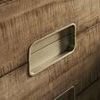 Close-up of brass campaign-style drawer pulls and detailed mocha wood grain texture on drawers