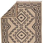 Back side of the rug folded to show reverse weave and pattern alignment in beige and black