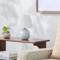 Ferez lamp in room setting on wooden table next to plant and beige sofa, showing full lamp in lifestyle context