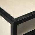 Close-up of top corner edge with visible glass inset over woven raffia surface and black frame